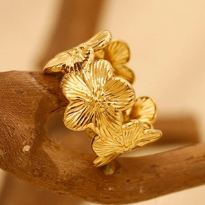 Detailed close-up of 18K gold plated flower ring on a natural wooden branch