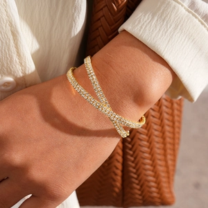 Close-up of luxury gold-plated double-row pavé diamond wrap bracelet on woman's wrist