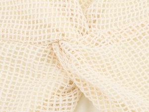 Detailaufnahme des beigen Strickgewebes mit komplizierter Knotentextur und Hohlraum-Design