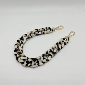Detail of zebra pattern acrylic chunky chain with glossy gold lobster clasps for bags