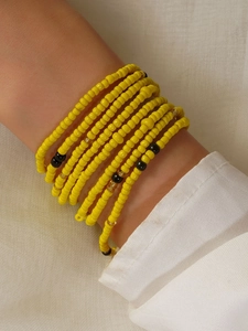 Close-up of bohemian handmade colorful beaded body chain with vibrant yellow seed beads