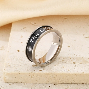 Detailed shot of black drip glaze titanium steel ring with diamond on marble base