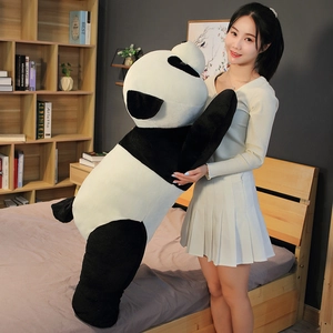 Vue détaillée d'une peluche géante de panda montrant sa grande taille face au mannequin