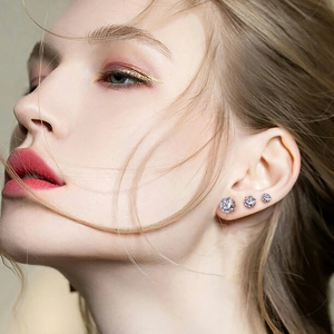 Close-up of S925 sterling silver triple gradient CZ stud earrings on model's ear