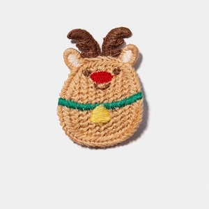 Détail d'une pince à cheveux renne de Noël tricotée main avec nez rouge et clochette