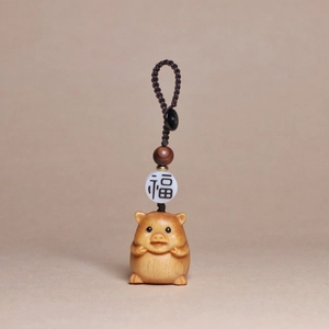 Detailed view of hand-carved wooden pig pendant with woven rope and blessing bead
