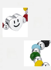 Détail macro du charm cœur sourire en argent S925 et bague avec perles colorées