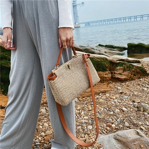 Vintage straw shoulder bag with brown leather straps and metal lock for beach summer
