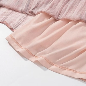 Dettaglio dell'orlo a doppio strato con texture in chiffon plissettato e finitura tie-dye