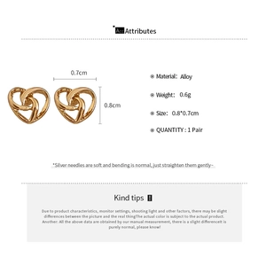 Macro detail of heart-shaped hollow stud earrings with silver needles and alloy material