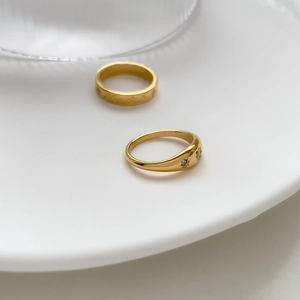 Minimalist gold star and moon open rings with sparkling zircon stones on white ceramic