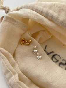 Macro shot of S925 sterling silver heart studs with zircon in gold and silver finish