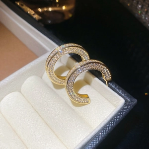 Detail shot of gold C-shaped earrings with shimmering pave-set cubic zirconia on velvet
