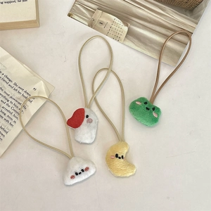 Detail of four cute plush hair ties featuring dog, moon, and frog embroidery motifs