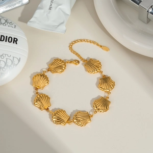 Detailed macro view of the gold-tone stainless steel seashell chain bracelet link