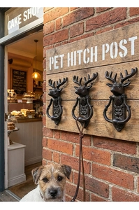 Detail of vintage cast iron deer head pet hitch post mounted on a rustic wood board