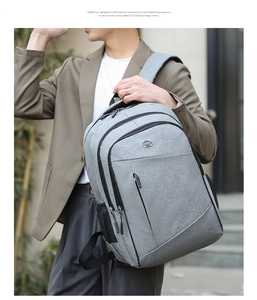 Detail showing grey Oxford cloth backpack with metal SPORT logo and black zippers