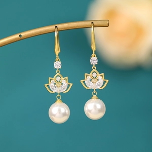 Detail view of pearl drop earrings with golden lotus design and zircon inlay