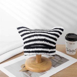 Close-up of black and white striped crochet knit hat with cute cat ear design detail