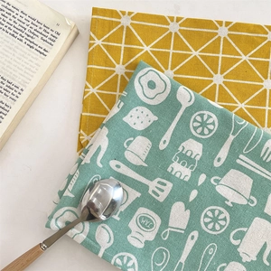 Détail de serviettes en coton et lin avec motifs géométriques jaunes et de cuisine
