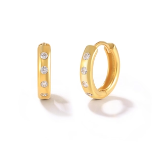 Detail of gold huggie hoop earrings with micro-set sparkling crystals on white background
