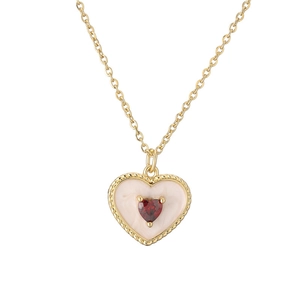 Gold plated heart necklace featuring red gemstone and cream enamel inlay on white background
