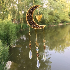Detail of moon-shaped suncatcher with tiger eye stones and crystal prism pendant