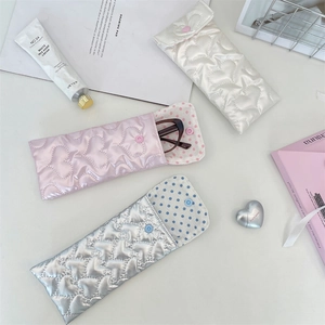 Detail of heart quilted PU pouches in pink, white, and silver with soft padding