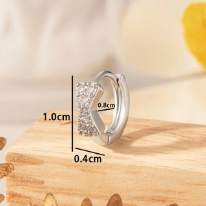 Silver bow knot hoop earrings with cubic zirconia stones on wooden display stand