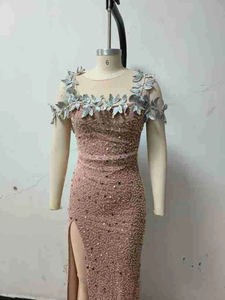 Detailed close-up of pink sequined evening gown featuring 3D floral appliques and thigh-high slit