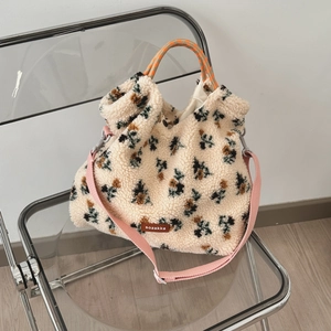 Macro view of fluffy beige lamb wool tote bag with floral patterns and pink strap