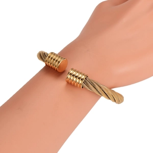 Minimalist golden stainless steel cable wire open cuff bracelet worn by a model