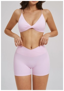 Detail of pink yoga set featuring a twisted sports bra and V-cross waist shorts
