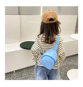 Detail showing a light blue toddler crossbody bag with adjustable strap on a child