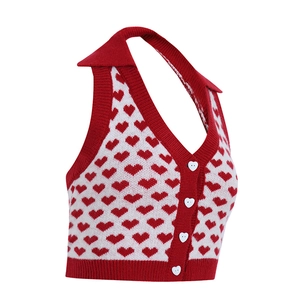 Dettaglio del gilet in maglia bianco e rosso con motivi a cuore e bottoni a forma di cuore
