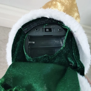 Detail view of the battery compartment and power switch under the plush Santa toy