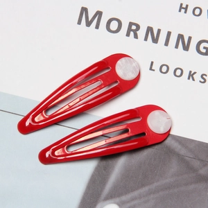 Close-up of red metal water drop hair clips with white decorative round buttons