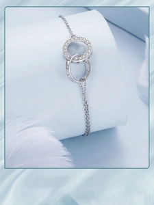 Close-up of interlocking double ring bracelet with zircon inlay and heart cut-out details