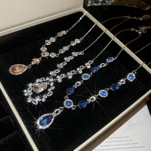 Detailansicht von vier eleganten Diamant-Halsketten mit rosa und blauen Wassertropfen