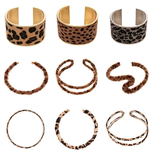 Nine styles of leopard print cuff bracelets in gold and silver metal with faux fur details