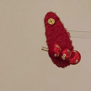 Detail of red flocked water-drop hair clip with golden star sequins and beads