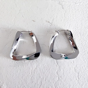 Macro shot of silver twisted triangular geometric earrings with mirror polished finish