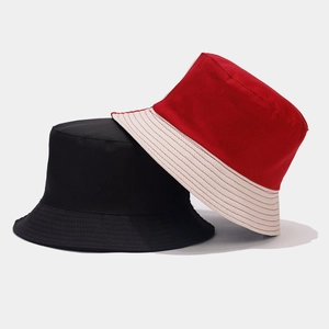 Détail de la texture des bobs réversibles noirs et à rayures rouges et blanches pour le soleil