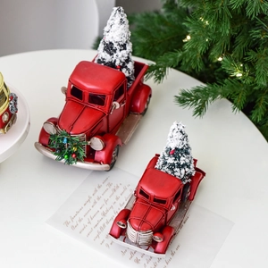 Vintage red metal Christmas pickup truck with mini trees and wreaths for holiday decor