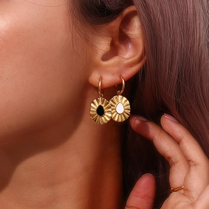 Detail of vintage gold fan earrings with black and white drop accents on model