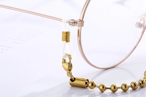 Macro detail of golden bead eyewear chain with silicone loops and lobster clasp