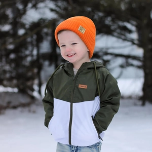 Detail of children orange knit beanie with logo tag and two-tone winter parka jacket