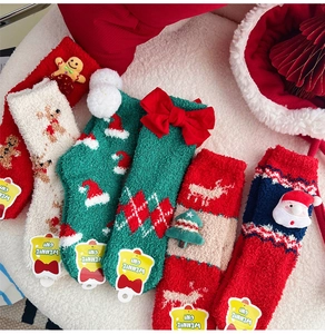 Gros plan de chaussettes de Noël épaisses en polaire corail avec motifs de cerf et Père Noël