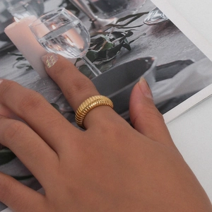 Detailed view of an 18K gold plated striped ring worn by a model in lifestyle setting