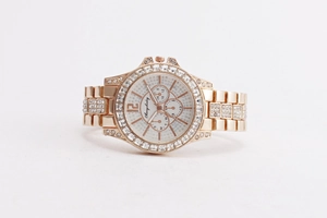 Macro view of rose gold quartz watch with rhinestones on bezel and multi-dial face